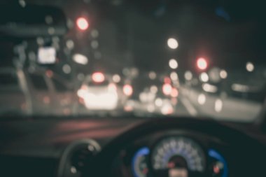 Arka plan kullanımı için gece vakti araba kullanan insanların klasik ton bulanık görüntüsü. (içeriden fotoğraf çek)