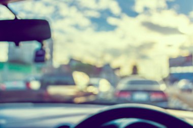 Arka plan kullanımı için gündüz vakti araba kullanan insanların klasik ton bulanık görüntüsü. (içeriden fotoğraf çek)