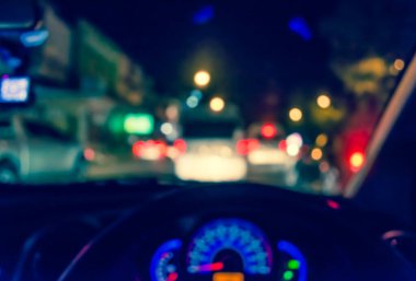 Arka plan kullanımı için gece vakti araba kullanan insanların klasik ton bulanık görüntüsü. (içeriden fotoğraf çek)