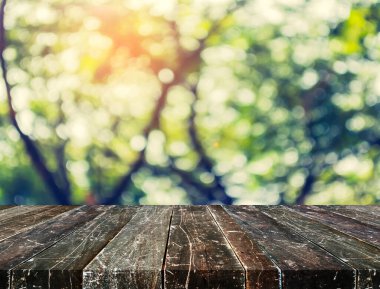 Ahşap tablo ve arkaplan kullanımı için güneşi olan soyut yeşil ağaç Bokeh 'in bulanık görüntüsü.