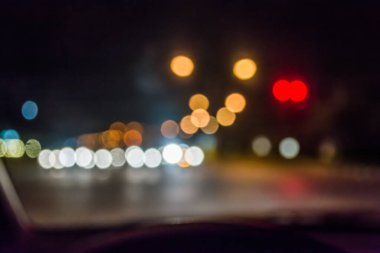 Arka plan için gece vakti trafik sıkışıklığından gelen bokeh ışıkları olan içerideki arabaların bulanık görüntüsü.