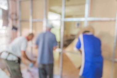 Arkaplan kullanımı için ev duvarını tamir eden insanların bulanık görüntüsü.