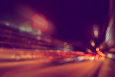 Gece vakti arka planda havai fişeklerle caddede araba görüntüsü bulanık.