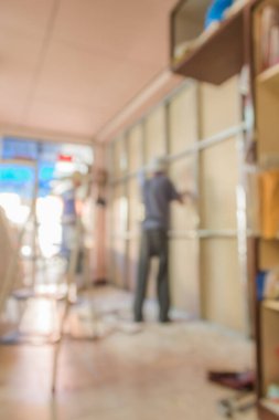 Arkaplan kullanımı için ev duvarını tamir eden insanların bulanık görüntüsü.