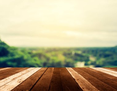 Arka planda dağ tepeleri ve kasaba manzaralı ahşap masanın klasik ton görüntüsü.