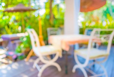 Arka plan kullanımı için yeşil ağaç bokeh ile gündüz vakti bulanık bir restoran görüntüsü .