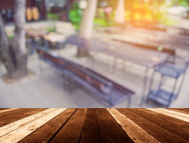 Ahşap tablolar ve sandalye bulanık görünümü arka plan kullanımı için bir açık hava partisi için hazırlandı.