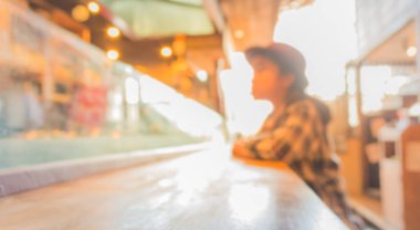 Japon restoranının bulanık görüntüsü ve arka plan kullanımı için yemeğini bekleyen bayan müşteri..