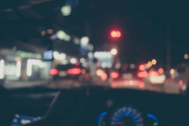 Arka plan kullanımı için gece vakti araba kullanan insanların klasik ton bulanık görüntüsü. (içeriden fotoğraf çek)