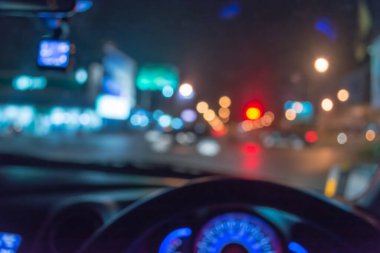 Arka plan için gece vakti trafik sıkışıklığından gelen bokeh ışıkları olan içerideki arabaların bulanık görüntüsü.