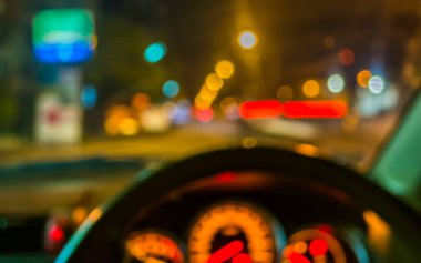 Gece vakti trafik sıkışıklığından gelen bokeh ışıkları olan içerideki arabaların bulanık görüntüsü.