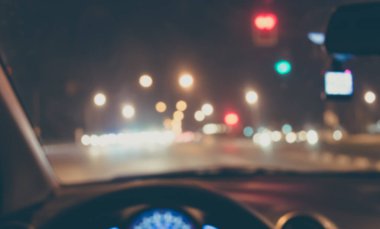 Arka plan kullanımı için gece vakti araba kullanan insanların klasik ton bulanık görüntüsü. (içeriden fotoğraf çek)