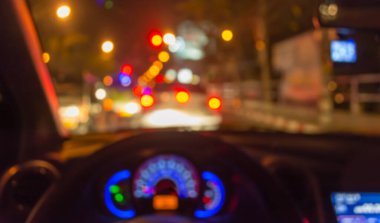 Arka plan için gece vakti trafik sıkışıklığından gelen bokeh ışıkları olan içerideki arabaların bulanık görüntüsü.