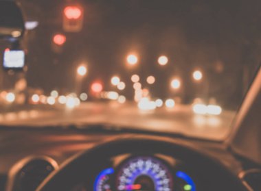 Arka plan kullanımı için gece vakti araba kullanan insanların klasik ton bulanık görüntüsü. (içeriden fotoğraf çek)