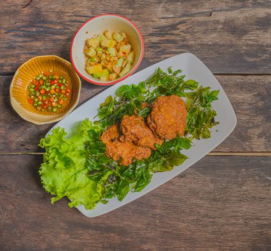 Kızarmış balık keki resmi (Tod Man Pla), ahşap masada Tayland aperatifi.