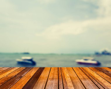 Akşam vakti ahşap masa ve bulanık deniz görüntüsü. (Klasik ton))
