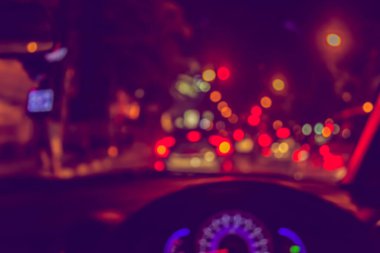 Arka plan kullanımı için gece vakti araba kullanan insanların klasik ton bulanık görüntüsü. (içeriden fotoğraf çek)