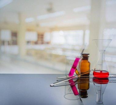 Arka planda bulanık laboratuarı olan laboratuvar camları.