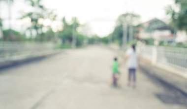 Arka plan kullanımı için yeşil bahçeye açık alanda bisiklet süren insanların klasik ton bulanık görüntüsü .