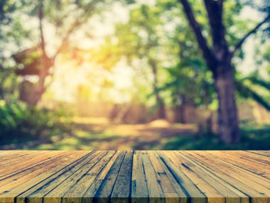 Ahşap tablo ve yeşil ağaçlı soyut Bokeh 'in bulanık görüntüsü arka plan kullanımı için kulübeyi görmek istiyor.