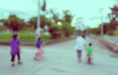 Arka plan kullanımı için yeşil bahçeye açık alanda bisiklet süren insanların klasik ton bulanık görüntüsü .