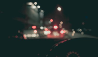 Arka plan kullanımı için gece vakti araba kullanan insanların klasik ton bulanık görüntüsü. (içeriden fotoğraf çek)