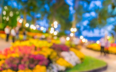 Arka plan kullanımı için bahçe gecesinde restoranın ve çiçeğin bulanık görüntüsü.