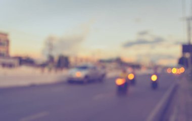 Arka plan kullanımı için akşam vakti yolda bulanık bir araba görüntüsü. (Klasik ton))