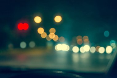 Arka plan için gece vakti trafik sıkışıklığından gelen bokeh ışıkları olan içerideki arabaların klasik ton bulanık görüntüsü.