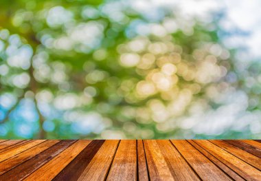 Yaz arkaplanı için ahşap tablo ve Soyut Bokeh yeşil ağaç renginin bulanık görüntüsü.