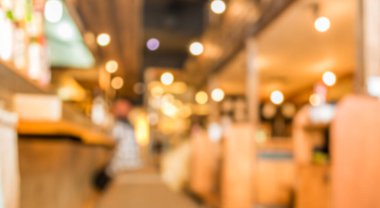 Japon restoranının bulanık görüntüsü ve arka plan kullanımı için yemeğini bekleyen bayan müşteri..