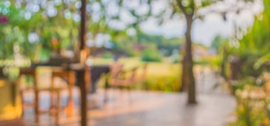 Arka plan kullanımı için bahçedeki bulanık masa ve sandalyelerin görüntüsü.