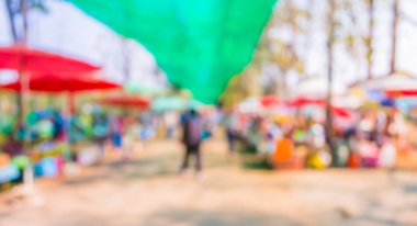 Güneşli bir günde pazar yerinde yürüyen insanların bulanık görüntüsü, Bokeh ile arka plan bulanık .