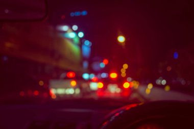 Arka plan kullanımı için gece vakti araba kullanan insanların klasik ton bulanık görüntüsü. (içeriden fotoğraf çek)