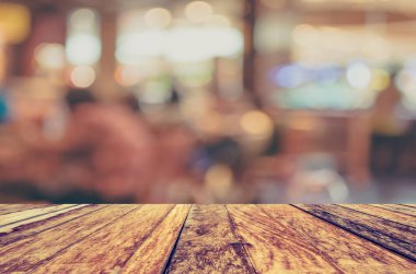 Ahşap masa ve kahve dükkanı arkaplanı Bokeh ile bulanık görünüm .