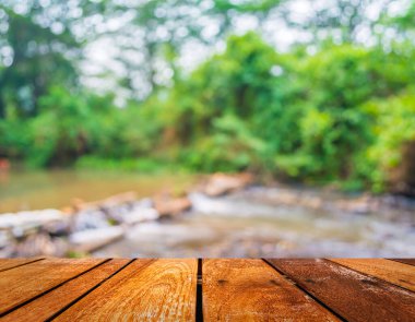 Ahşap iskele ya da yürüyüş yolu ya da geçmişi bulanık nehir ve insanların olduğu eski bir ahşap masa.
