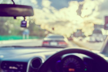 Arka plan kullanımı için gündüz vakti araba kullanan insanların klasik ton bulanık görüntüsü. (içeriden fotoğraf çek)