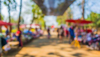 Güneşli bir günde pazar yerinde yürüyen insanların bulanık görüntüsü, Bokeh ile arka plan bulanık .