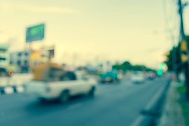 Arka plan kullanımı için akşam vakti yolda bulanık bir araba görüntüsü. (Klasik ton))