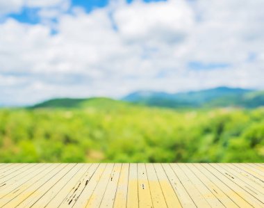 Ahşap masa ve arka planda yeşil dağın bulanık görüntüsü .
