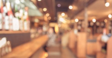 Japon restoranının bulanık görüntüsü ve arka plan kullanımı için yemeğini bekleyen bayan müşteri..