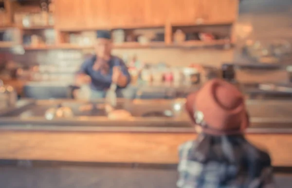 blur image of japan restaurant and lady customer waiting for her meal for background usage.