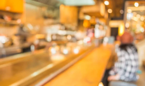 blur image of japan restaurant and lady customer waiting for her meal for background usage.