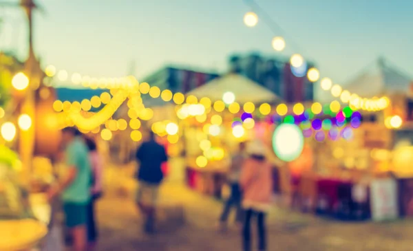 vintage tone blur image of night festival on street blurred background with bokeh .