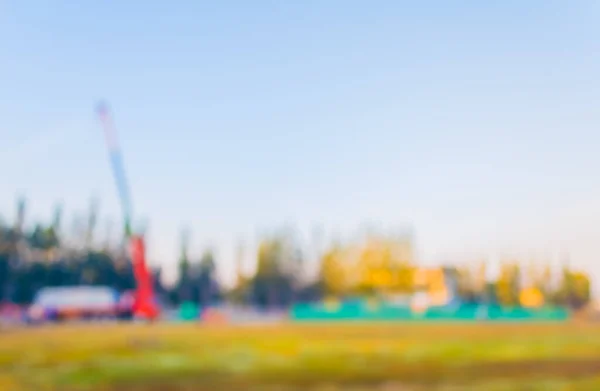 blur image of property construction site with cranes and clear blue sky for background usage.