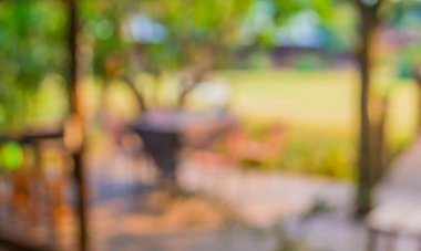 Arka plan kullanımı için bahçedeki bulanık masa ve sandalyelerin görüntüsü.