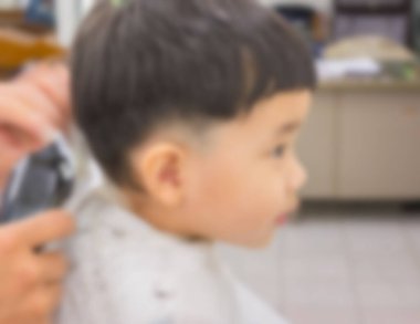 Arka plan kullanımı için berber dükkanındaki Asyalı çocuğun bulanık görüntüsü.