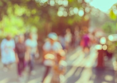 Arka plan kullanımı için Bokeh ile parkta yürüyen insanların klasik ton bulanık görüntüsü .