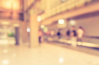 Ofis merkezinde arka plan kullanımı için uzun koridorda yürüyen insanların klasik ton soyut bulanık görüntüsü .