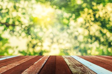 Arkaplan kullanımı için ahşap tablo ve yeşil ağaç bokeh 'in soyut bulanık resmi .